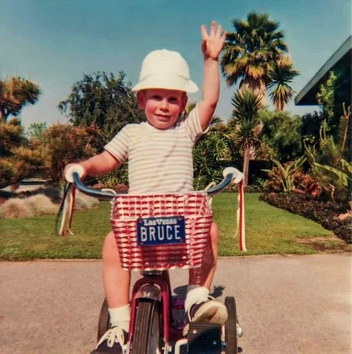 Proudly showing off my Las Vegas vanity plate while waving from atop my shiny red tricycle in the driveway of our new home at 15472 Huston Street, Sherman Oaks - 1967.