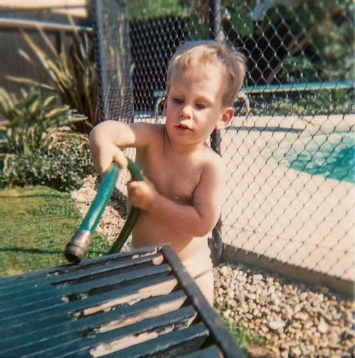 Hosing off the built-in bench in our backyard at Huston Street - 1967.